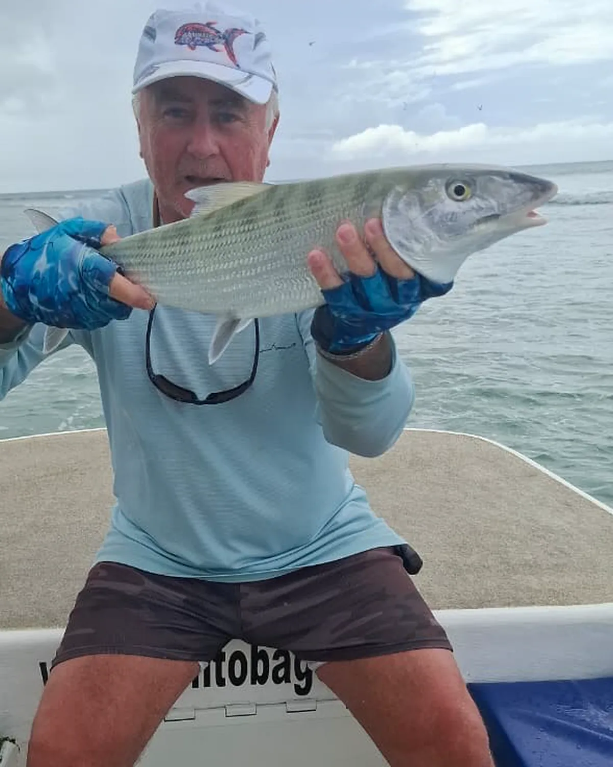 A bonefish held across the boat seat before it goes back