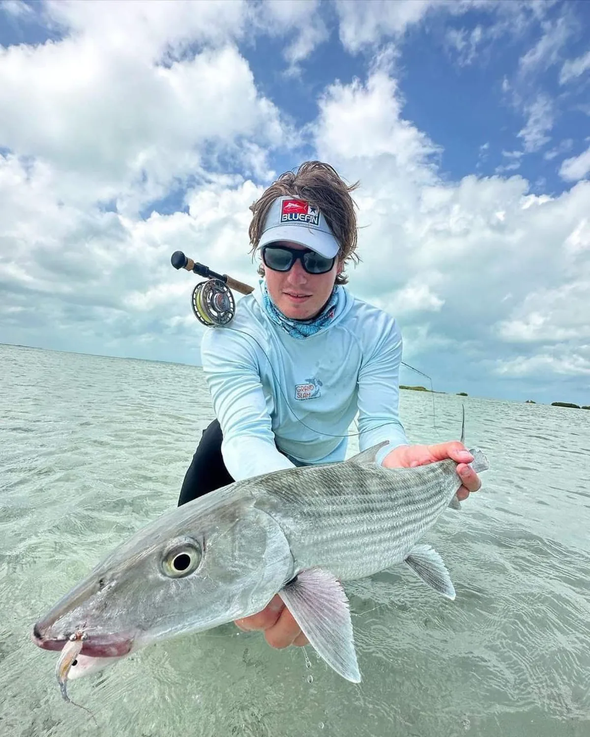 A bonefish held low over the water before release
