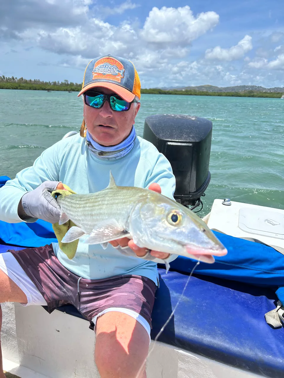 A bonefish held low over the water before release