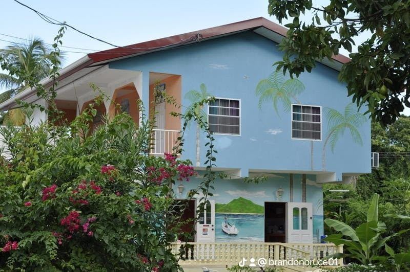 The guest house with its painted mural of palms and the bay