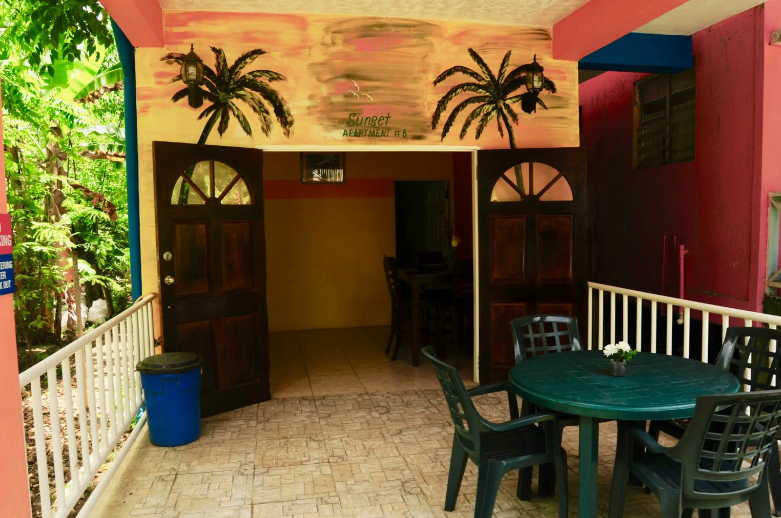 The guest house entrance, palms painted across the wall and the dining tables just inside