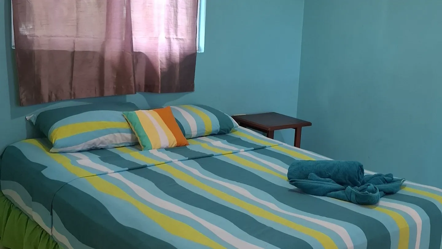 Coral Gardens' queen bed against turquoise walls