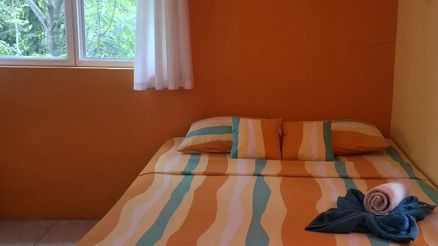 Sweet Breeze Maria's queen bed, with a window onto the trees